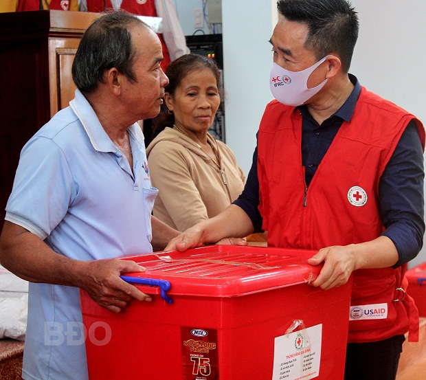 Phó Chủ tịch Hội CTĐ Việt Nam Nguyễn Hải Anh trao thùng hàng gia đình cho người dân bị thiệt hại sau bão tại TX Hoài Nhơn. Ảnh: NGỌC TÚ