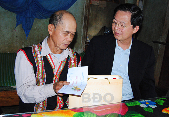 Bí thư Tỉnh ủy Hồ Quốc Dũng (bìa phải) đến thăm, tặng quà Tết cho gia đình ông Đinh Văn Móp, ở thôn 1, xã Ân Sơn, là người có uy tín trong đồng bào dân tộc thiểu số ở địa phương.