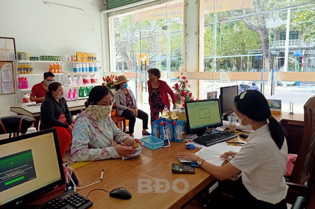 Người dân đến điểm bưu điện trên đường Hai Bà Trưng, TP Quy Nhơn nhận lương hưu hai tháng 4 và 5.2020.
